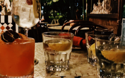 A cocktail and water glass set on a mosaic table at Beatnik.